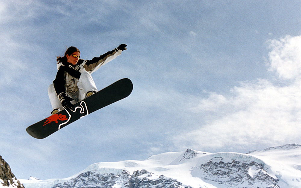 Девушка прыгает на сноуборде