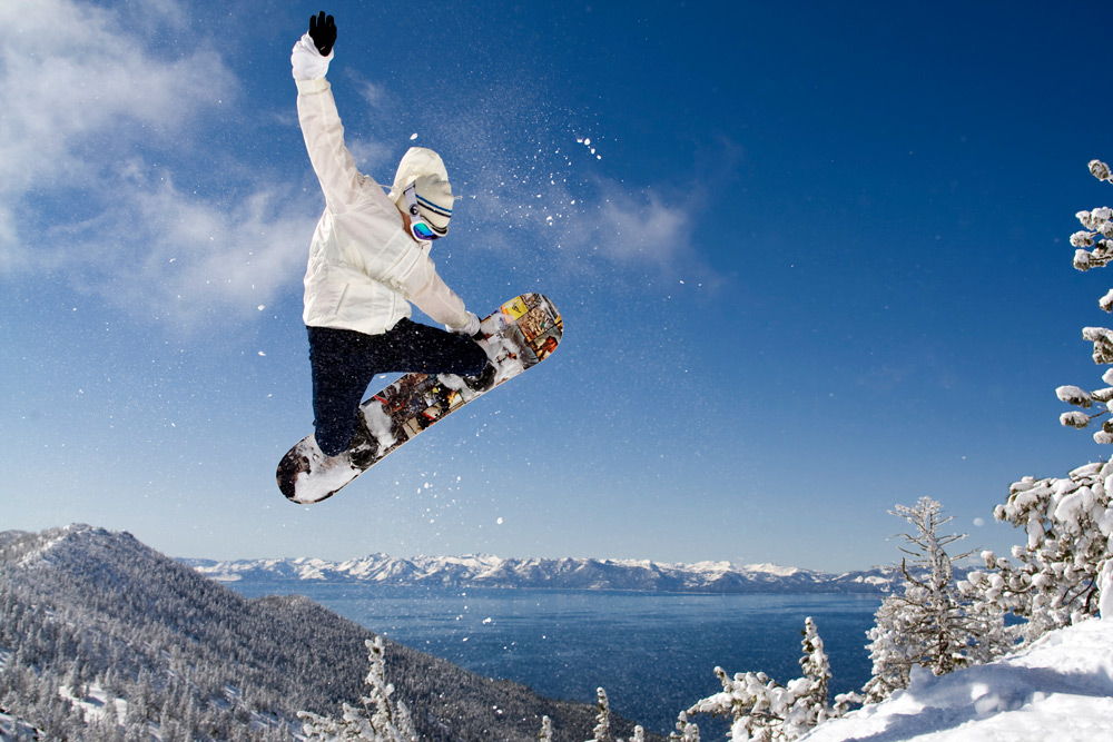 Человек выполняет прыжок на сноуборде