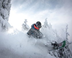 Человек спускается на сноуборде в горах